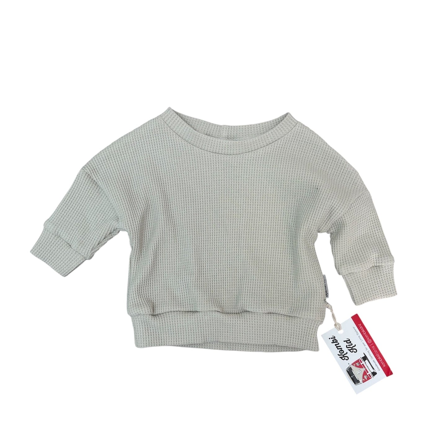 Light gray ribbed sweater with a tag on a white background